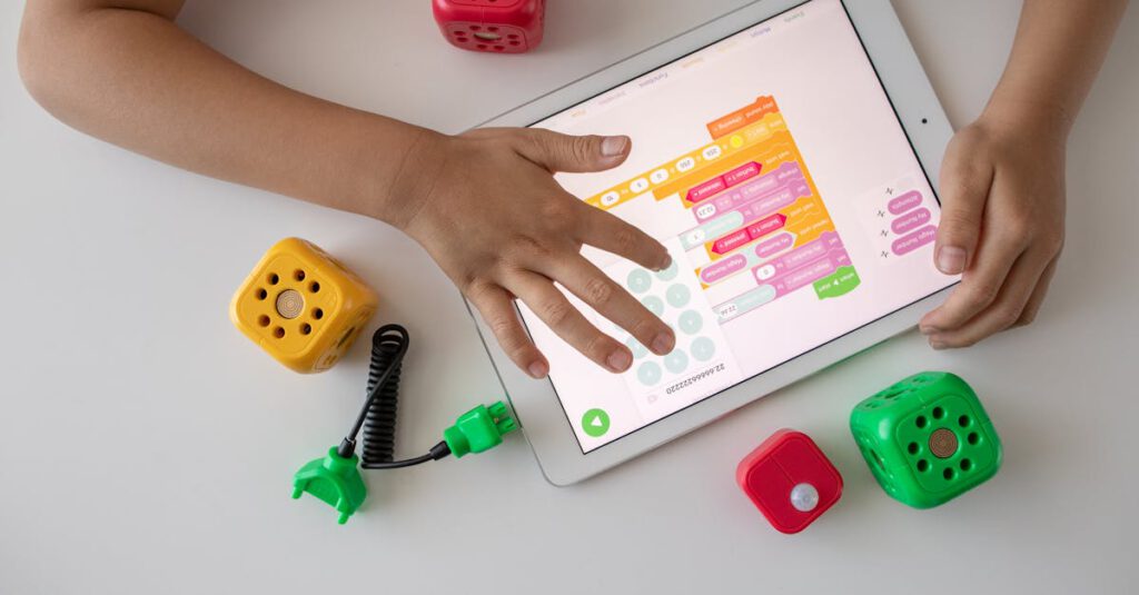 Child using digital tablet for coding education alongside colorful toy blocks.